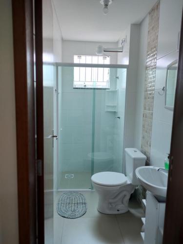 a bathroom with a shower and a toilet and a sink at Apê aconchegante in São José
