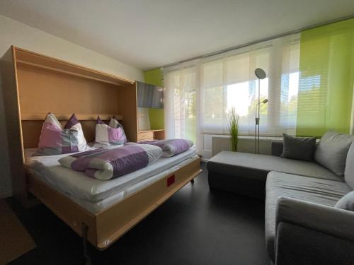 um quarto com uma cama e um sofá em Ferienapartment Auszeit wie dahoam Am Predigtstuhl em Sankt Englmar