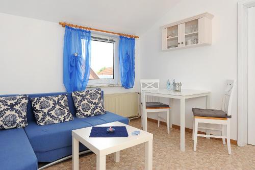 uma sala de estar com um sofá azul e uma mesa em Haus Sonnenperle em Utarp