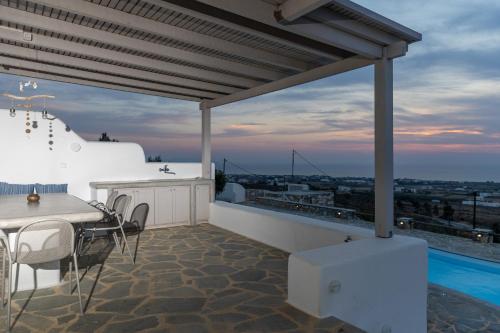 un patio con tavolo, sedie e piscina di Villa Livana Naxos a Kastraki