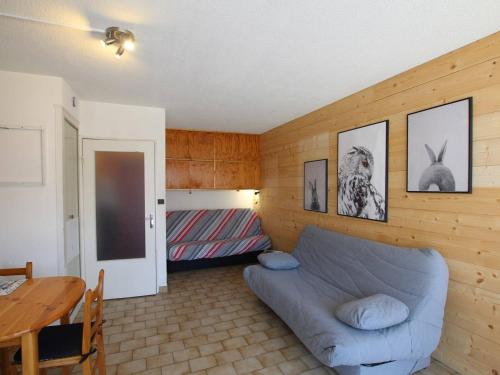 ein Wohnzimmer mit einem blauen Sofa und einem Tisch in der Unterkunft Studio cosy au cœur de Briançon avec parking - FR-1-330C-47 in Briançon