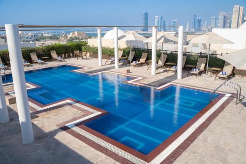 a swimming pool on the roof of a building at Mövenpick Hotel Apartments Al Mamzar Dubai in Dubai