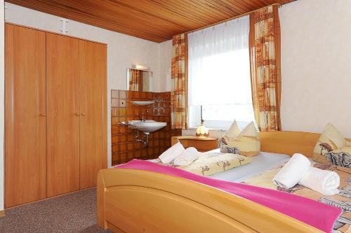 um quarto com uma cama com um lavatório e uma janela em Haus Sonnenperle em Utarp