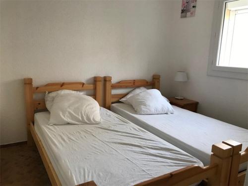 deux lits jumeaux dans une chambre avec fenêtre dans l'établissement Magnifique T2 en bord de mer, 4 couchages, terrasse, parking, plage à pied, proche commerces et Aqualand - FR-1-81-56, à Port-Leucate