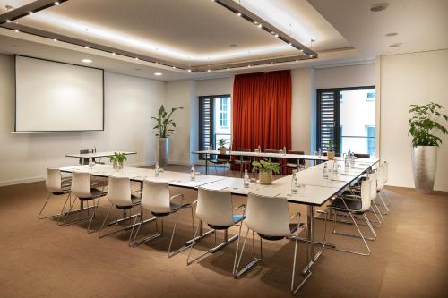 a conference room with a long table and chairs at INNSiDE by Meliá Dresden in Dresden