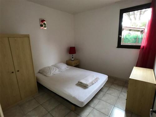 - une petite chambre avec un lit blanc et une fenêtre dans l'établissement Appartement Port Leucate, 3 pièces, 6 personnes - FR-1-81-83, à Port-Leucate