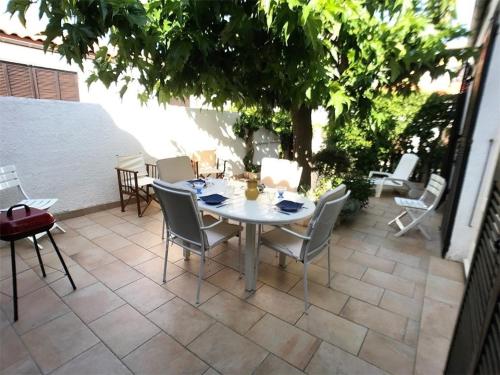 une table et des chaises assises sur une terrasse dans l'établissement Charmante Villa T3 à Port Leucate, 5 couchages, proche plage, barbecue, garage - FR-1-81-98, à Port-Leucate