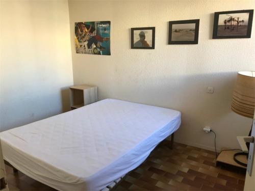 une salle d'hôpital avec un lit blanc et des photos sur le mur dans l'établissement T2 à 50m de la plage, Parking privé, 4 pers - FR-1-81-117, à Port-Leucate