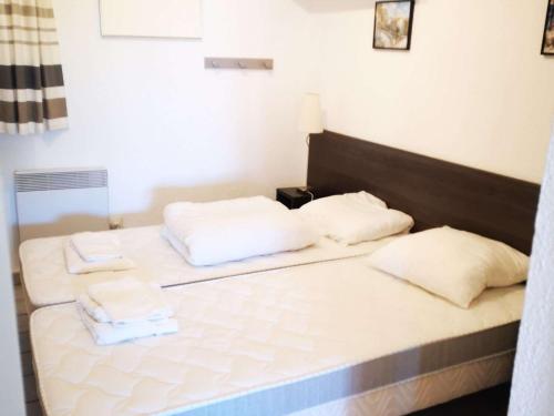 Una cama con dos almohadas blancas encima. en Appartement Port Barcarès, 2 pièces, 4 personnes - FR-1-195-7, en Le Barcarès