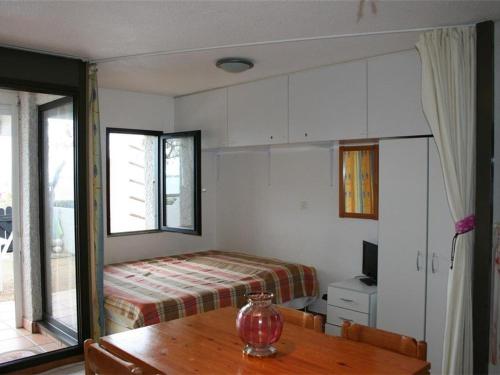 - une chambre avec un lit et une table en bois dans l'établissement Charmant T2 Cabine avec terrasse et piscine à Port Barcarès - FR-1-195-13, au Barcarès