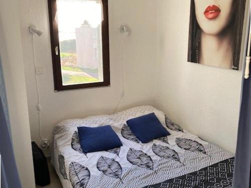 Cette petite chambre comprend un lit avec deux oreillers bleus. dans l'établissement Studio Cabine à Le Barcarès, 4 couchages, terrasse, parking, piscine et activités sportives - FR-1-195-23, au Barcarès