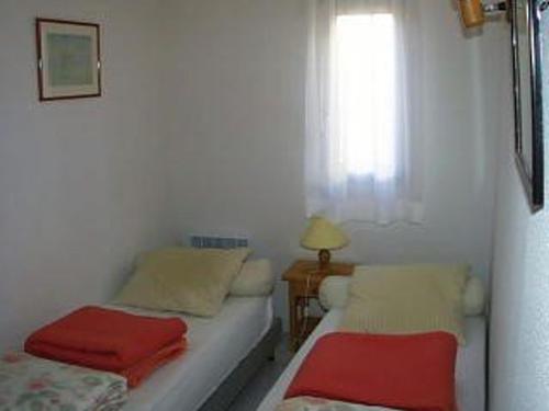 une petite chambre avec deux lits et une fenêtre dans l'établissement Appartement T3, 6 Pers, Pieds dans l'Eau au Barcarès, Terrasse et Parking - FR-1-81-157, au Barcarès