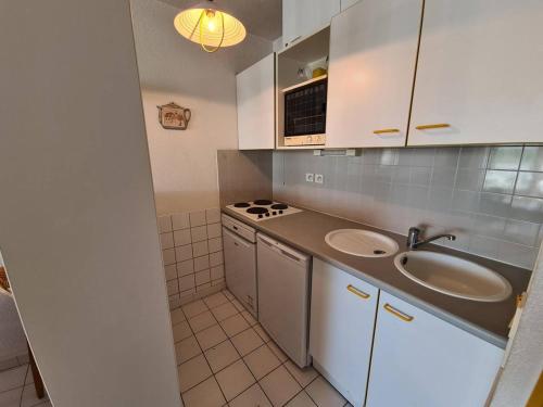 une petite cuisine avec un évier et une cuisinière dans l'établissement T2 Cabine, 4-6 pers, Parking, 150m plage - Argelès-sur-Mer - FR-1-388-16, à Argelès-sur-Mer