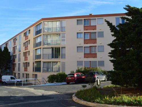 un immeuble d'appartements avec des voitures garées dans un parking dans l'établissement Appartement 2P avec parking à Banyuls-sur-Mer, proche du port - FR-1-225C-21, à Banyuls-sur-Mer