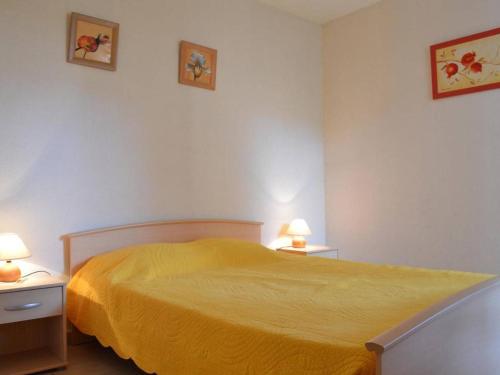 - une chambre avec un lit jaune et 2 tables de chevet dans l'établissement Appartement T2 avec Terrasse, Proche Plage - Argelès-sur-Mer - FR-1-225-78, à Argelès-sur-Mer