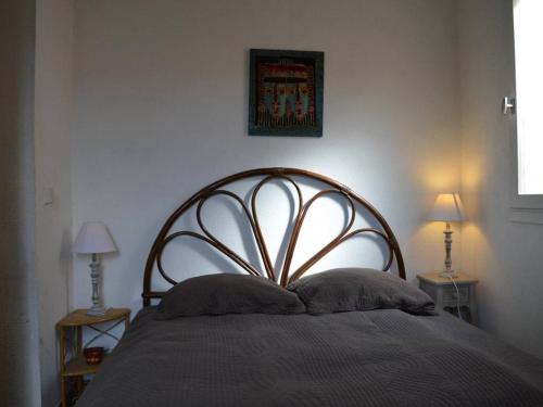 un lit dans une chambre avec deux lampes sur des tables dans l'établissement Maison avec jardin, piscine et parking - 4 couchages - plage à proximité - animaux acceptés - FR-1-225D-174, à Saint Cyprien Plage