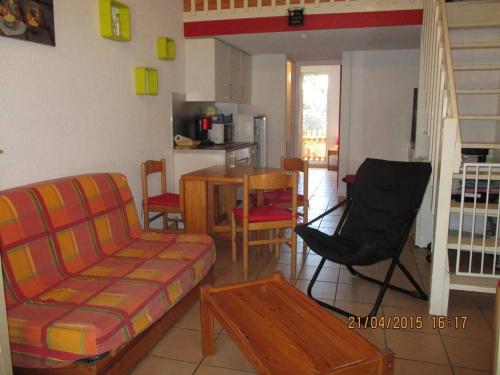 un salon avec un canapé, une table et des chaises dans l'établissement Maison 2 pièces mezzanine, 6 couchages, piscine, parking, terrasse Sud - St Cyprien Plage - FR-1-225D-216, à Saint Cyprien Plage