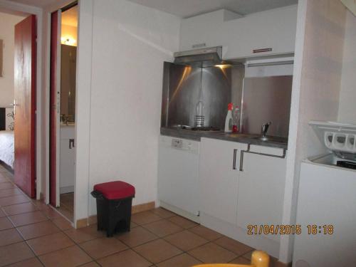 une cuisine avec des placards blancs et un tabouret rouge dans l'établissement Maison 2 pièces mezzanine, 6 couchages, piscine, parking, terrasse Sud - St Cyprien Plage - FR-1-225D-216, à Saint Cyprien Plage