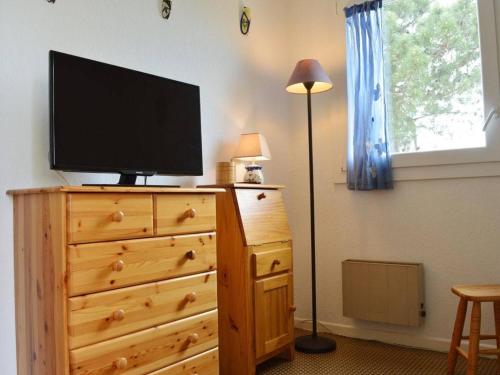 une télévision sur le dessus d'une commode en bois avec une lampe dans l'établissement Appartement familial climatisé, proche mer et commerces, 2 pièces, 4 couchages, terrasse équipée - FR-1-225-240, à Argelès-sur-Mer