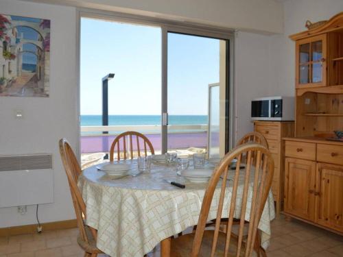 une cuisine avec une table avec des chaises et une vue sur l'océan dans l'établissement Appartement 2 pièces avec parking à Saint-Cyprien - FR-1-225D-193, à Saint Cyprien Plage