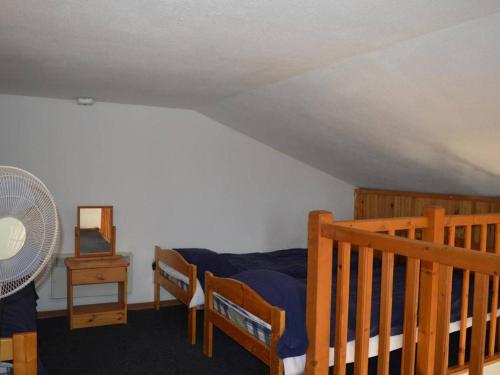 - une chambre avec un lit, une table et un ventilateur dans l'établissement Appartement familial 2 pièces + mezzanine, piscine, parking, à 1 km de la plage - Argelès-sur-Mer - FR-1-225-244, à Argelès-sur-Mer