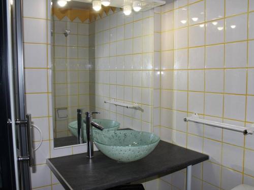 uma casa de banho com um lavatório e um espelho. em Maison Gruissan, 3 pièces, 6 personnes - FR-1-229-53 em Gruissan