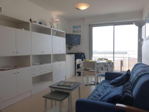 - un salon avec des placards blancs et un canapé bleu dans l'établissement Appartement 2 pièces avec balcon et parking à 1,5 km du centre de Saint-Gilles-Croix-de-Vie - FR-1-224-40, à Saint-Gilles-Croix-de-Vie