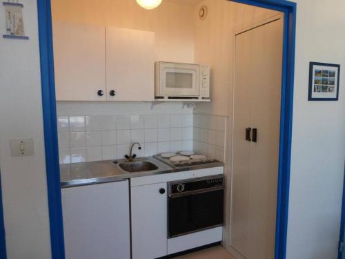 une petite cuisine avec un évier et un micro-ondes dans l'établissement Appartement 2 pièces avec balcon et parking à 1,5 km du centre de Saint-Gilles-Croix-de-Vie - FR-1-224-40, à Saint-Gilles-Croix-de-Vie