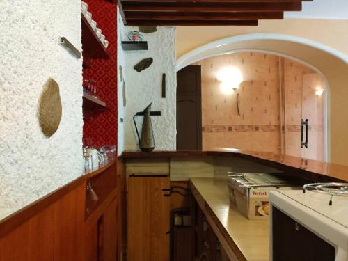 une cuisine avec un comptoir et une arche dans l'établissement Appartement 2 chambres, 8 couchages, centre-ville Cauterets, WiFi gratuit, parking à proximité - FR-1-234-89, à Cauterets