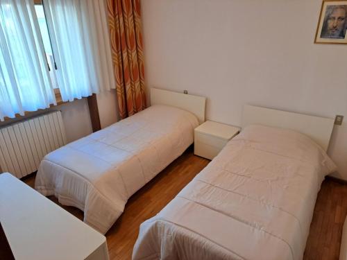 1 Schlafzimmer mit 2 Betten und einem Fenster in der Unterkunft CONCO HOUSE in Calalzo