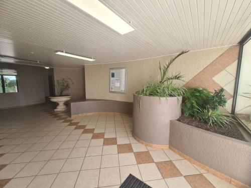 un couloir avec des plantes en pot dans un bâtiment dans l'établissement Studio avec balcon, parking sécurisé, proche plage - FR-1-224C-197, à Saint-Jean-de-Monts