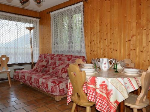 a dining room with a table and a couch at Appartement Le Grand-Bornand, 3 pièces, 6 personnes - FR-1-241-42 in Le Grand-Bornand