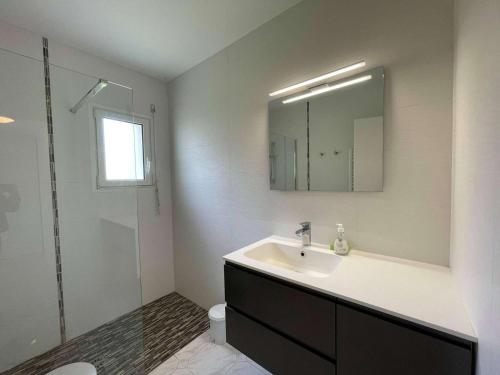 une salle de bain blanche avec un lavabo et un miroir dans l'établissement Appartement 4 pièces avec piscine - proche plage - Saint-Jean-de-Monts - FR-1-224C-214, à Saint-Jean-de-Monts