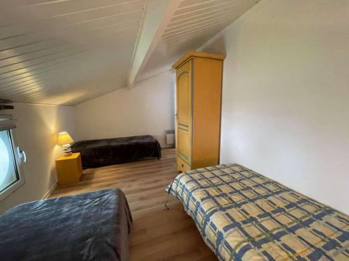 Cette chambre comprend 2 lits et une commode. dans l'établissement Appartement 4 pièces avec piscine - proche plage - Saint-Jean-de-Monts - FR-1-224C-214, à Saint-Jean-de-Monts