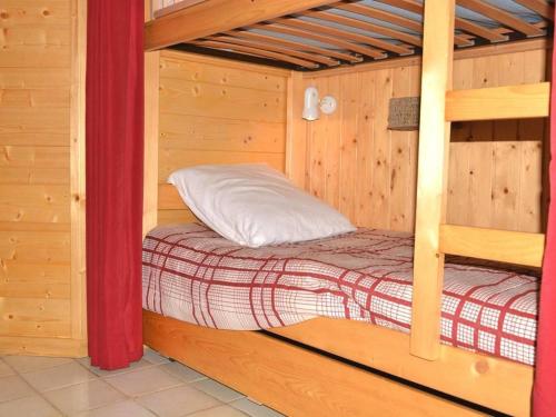 a bed in a wooden cabin with a bunk bed in it at Appartement Le Grand-Bornand, 2 pièces, 4 personnes - FR-1-241-91 in Le Grand-Bornand