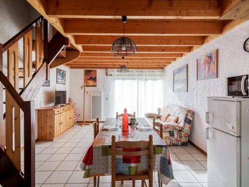 une cuisine et une salle à manger avec une table et un réfrigérateur dans l'établissement Appartement T3 6 pers avec jardinet, BBQ, proche thermes, parking privé, 3 stations de ski à proximité - FR-1-402-9, à Esquièze - Sère