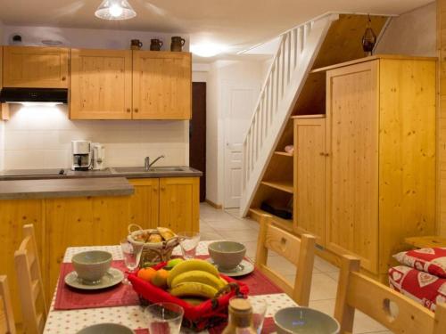 - une cuisine avec une table et des bananes dans l'établissement Appt cosy 3 pièces avec mezzanine - 6 couchages, parking, animaux admis - Grand Bornand - FR-1-241-104, au Grand-Bornand