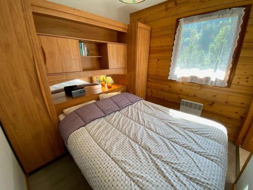 a bedroom with a bed in a wooden room at Appartement Le Grand-Bornand, 2 pièces, 6 personnes - FR-1-241-131 in Le Grand-Bornand