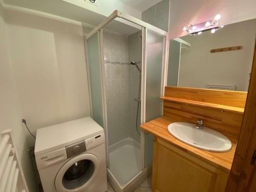 une salle de bain avec une machine à laver et un lavabo dans l'établissement Appartement chaleureux au Grand Bornand - 6 personnes, balcon, parking, proche centre - FR-1-241-131, au Grand-Bornand
