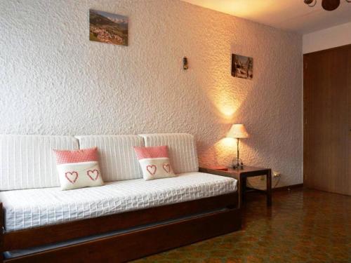 sala de estar con sofá blanco y almohadas rosas en Appartement Le Grand-Bornand, 1 pièce, 4 personnes - FR-1-241-80, en Le Grand-Bornand