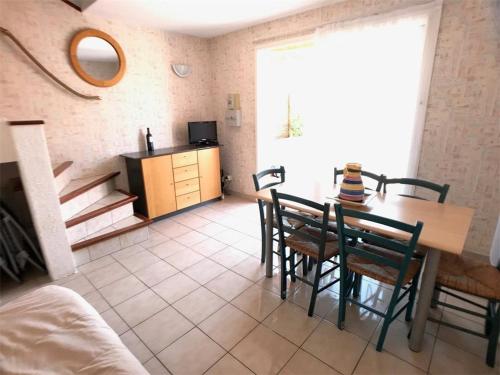une cuisine et une salle à manger avec une table et des chaises dans l'établissement Pavillon 6 personnes avec terrasse, parking et TV - Port Barcarès - FR-1-81-257, au Barcarès