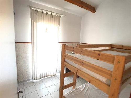 une chambre avec un lit superposé et une fenêtre dans l'établissement Pavillon 6 personnes avec terrasse, parking et TV - Port Barcarès - FR-1-81-257, au Barcarès