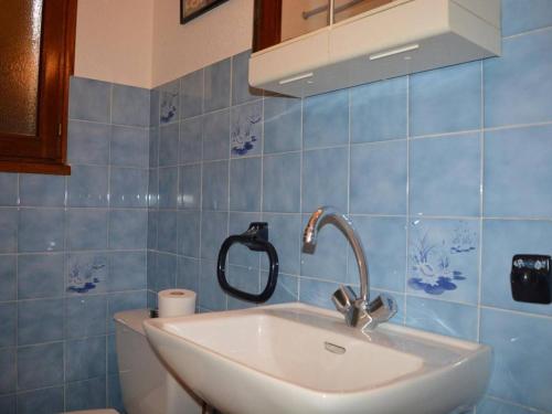 a bathroom with a sink and a blue tiled wall at Appartement Le Grand-Bornand, 1 pièce, 4 personnes - FR-1-241-95 in Le Grand-Bornand