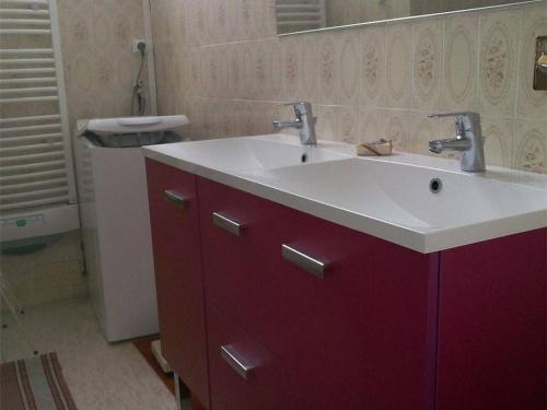 La salle de bains est pourvue d'un lavabo blanc et d'une armoire rouge. dans l'établissement Appartement 6 Pers, Centre-Ville Cauterets, Proche Télécabine et Thermes - FR-1-234-109, à Cauterets