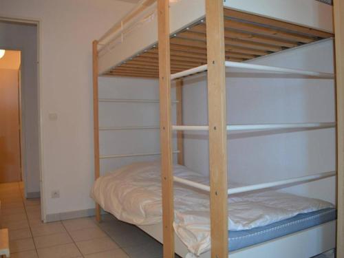 Ce lit superposé se trouve dans un dortoir doté de lits superposés en bois. dans l'établissement Appartement 3 pièces avec piscine et parking à Saint-Cyprien - FR-1-225D-315, à Saint-Cyprien
