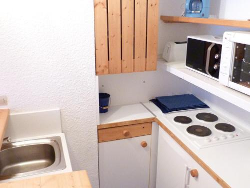 une petite cuisine avec un évier et un micro-ondes dans l'établissement Duplex chaleureux 6 pers, balcon sud, proche pistes et commerces, Arc 1800 - FR-1-411-40, à Arc 1800