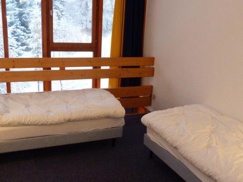 - une chambre avec deux lits en face d'une fenêtre dans l'établissement Duplex chaleureux 6 pers, balcon sud, proche pistes et commerces, Arc 1800 - FR-1-411-40, à Arc 1800