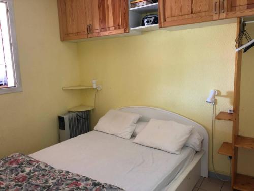 une chambre avec un lit avec deux oreillers dessus dans l'établissement T2+cabine climatisé avec parking, 4 pers., Port Leucate - FR-1-81-354, à Port-Leucate