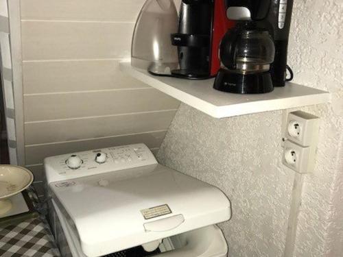 La salle de bains est pourvue de toilettes et d'une cafetière sur une étagère. dans l'établissement Appartement 2P+Mezzanine 5 pers, Mer et Parking, Port Barcarès - FR-1-81-191, à Port-Leucate