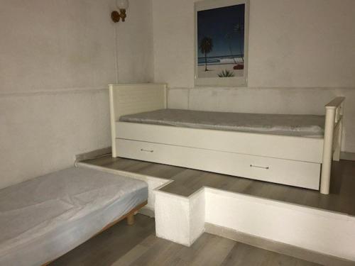 une chambre avec deux lits et un tableau au mur dans l'établissement Appartement 2P+Mezzanine 5 pers, Mer et Parking, Port Barcarès - FR-1-81-191, à Port-Leucate